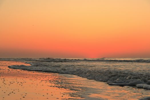 Beautiful sunset with vibrant orange sky over the ocean at Hilton Head Island, SC.