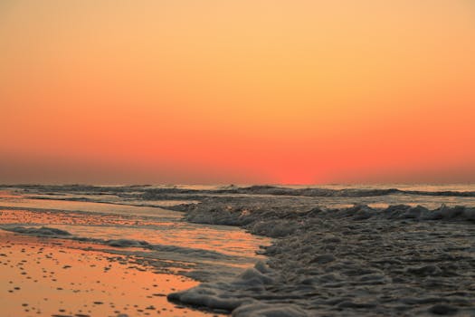 Capture the serene sunrise over Hilton Head Island's beach with vibrant colors and calming waves.