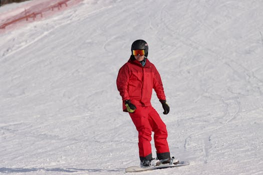 Teenager snowboarding in red gear on a snowy slope in Jönköping, Sweden.