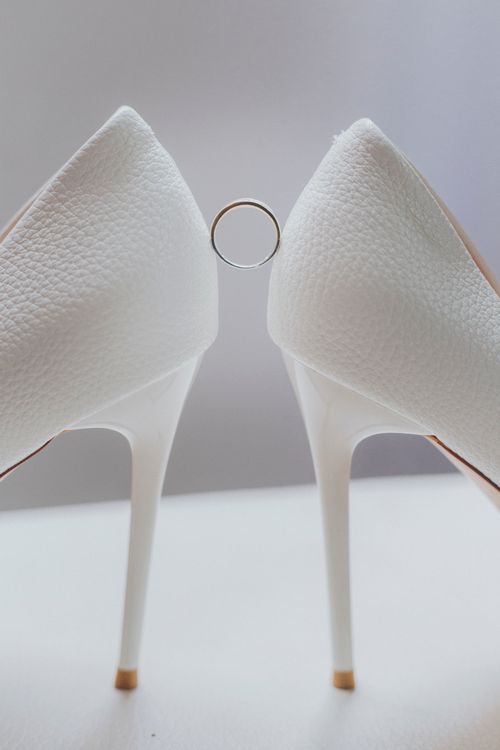Free Stylish white high heels showcasing a wedding ring in an elegant setup. Stock Photo