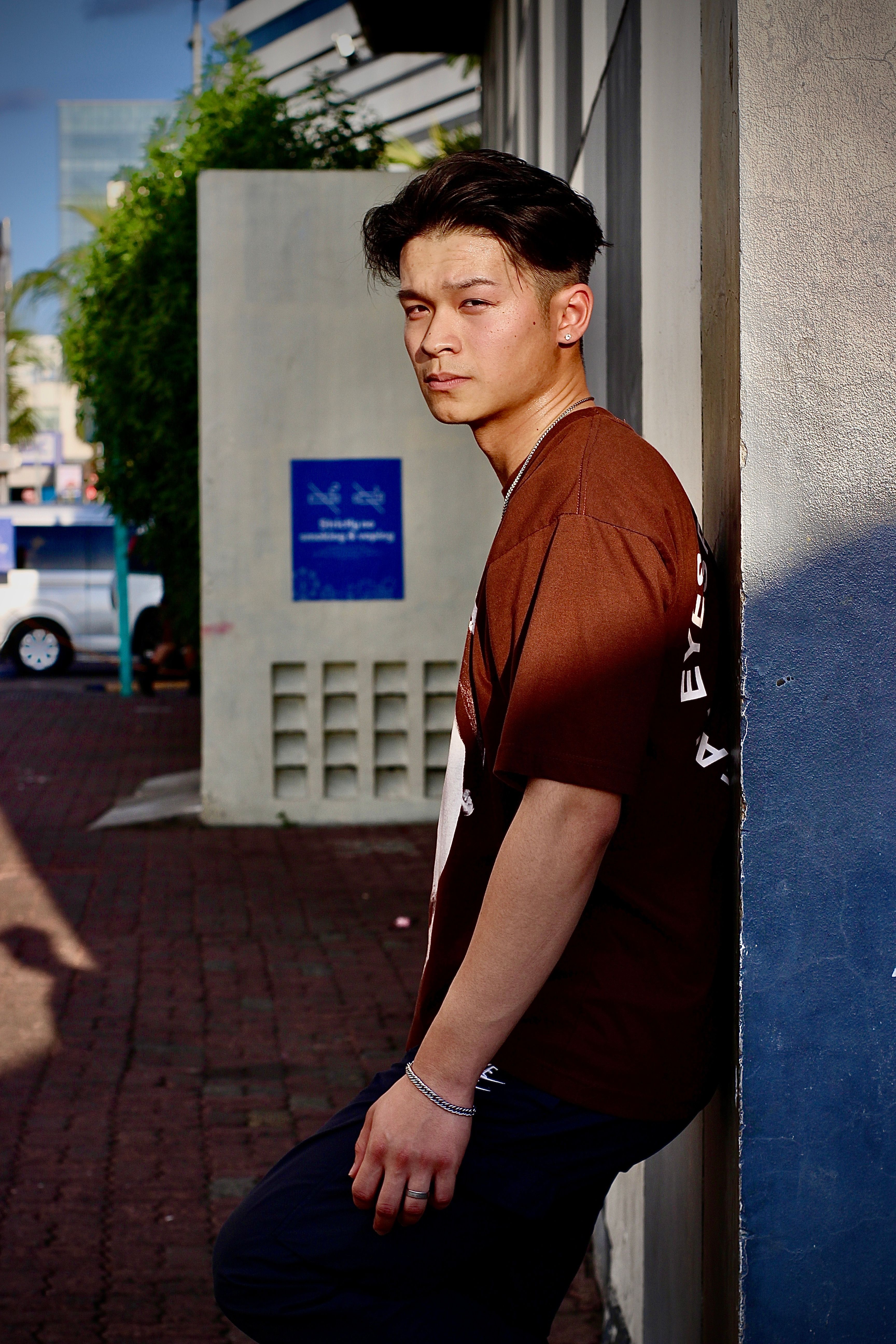 Casual portrait of a young man leaning against a wall on a sunny day in Pasay, Philippines.