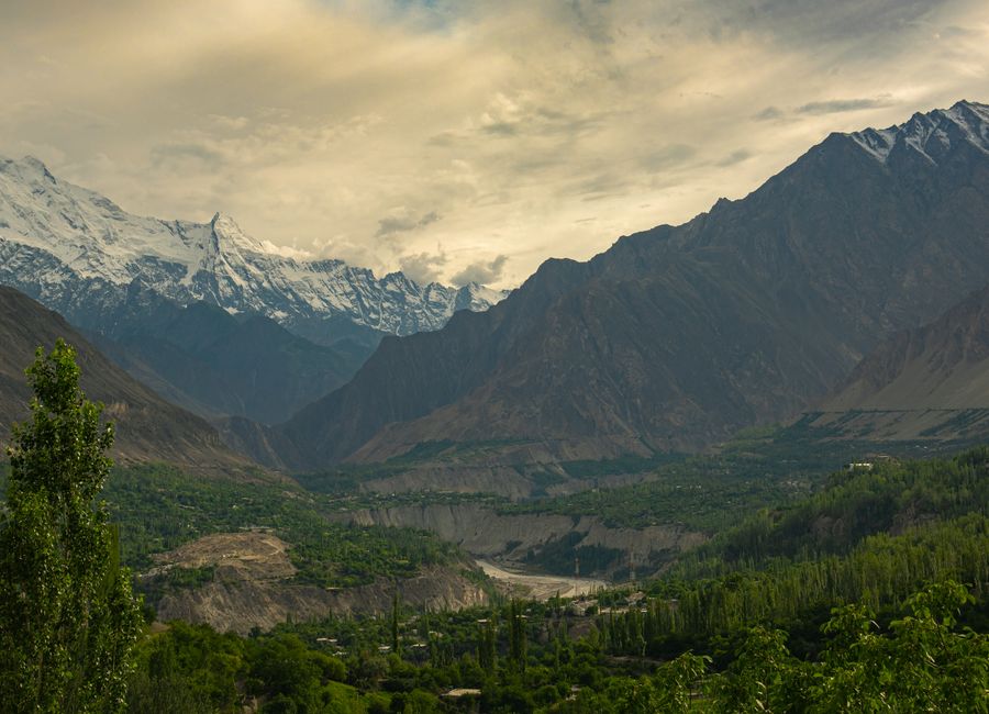 Breathtaking view of Hunza Valley with lush greenery and snow-capped peaks.