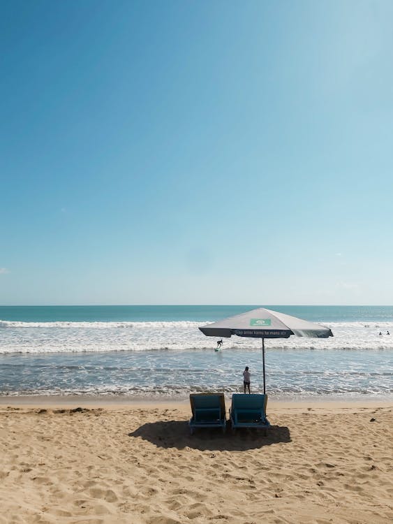 Clear Sky over an Umbrella and Deck Chairs on a Sandy Beach