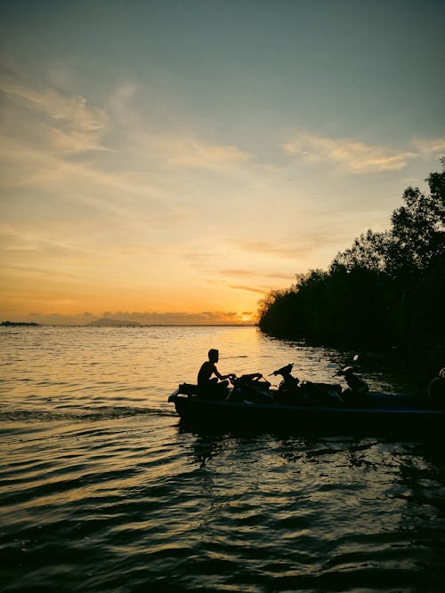 Man Sailing on Sea at Dawn