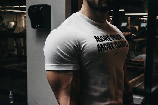 Close-up of a muscular man in a t-shirt training in an indoor gym setting.