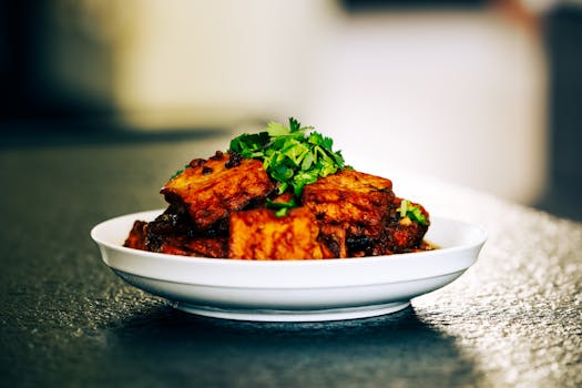 Savory roasted meat dish garnished with fresh herbs on a white plate, perfect for culinary presentations.