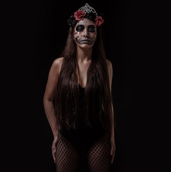 一名女子脸上涂着《亡灵节》彩绘，身着黑衣，背景为黑色