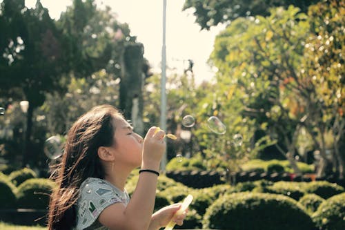 Girl Blowing a Bubbles on Wind