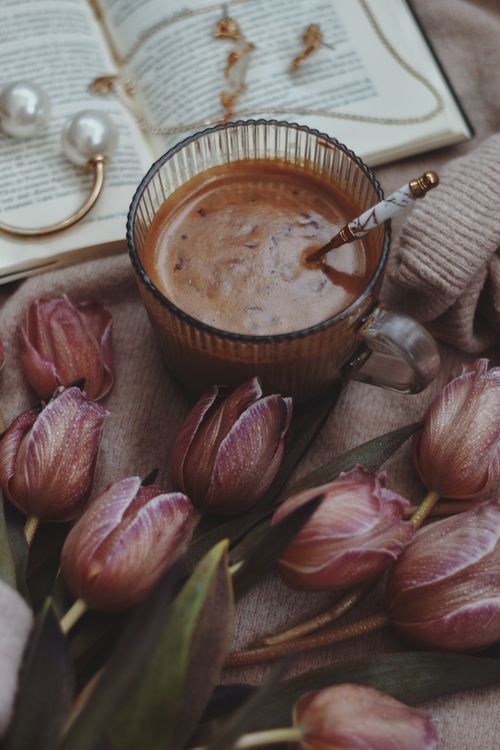 Free Warm scene of coffee, purple tulips, and an open book creating a cozy atmosphere. Stock Photo