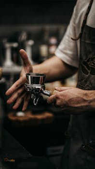 Close-up of a barista working with an espresso machine in a modern café setting.