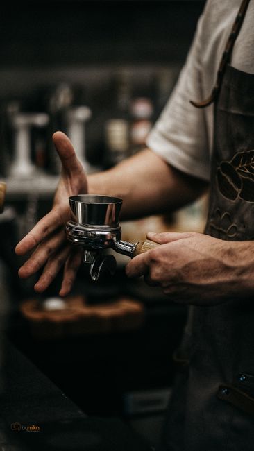 Close-up of a barista working with an espresso machine in a modern café setting.