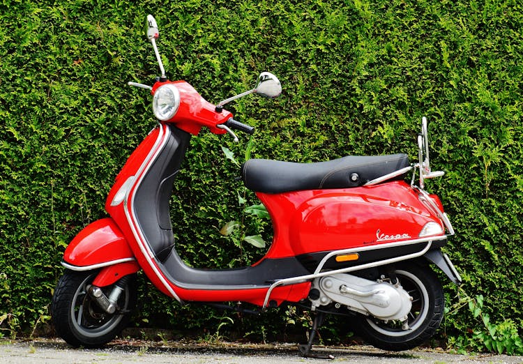 Red And Black Moped Scooter Beside Green Grass