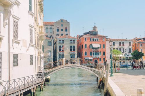 Free A picturesque canal view in Venice, Italy, showcasing historic architecture and a charming bridge. Stock Photo