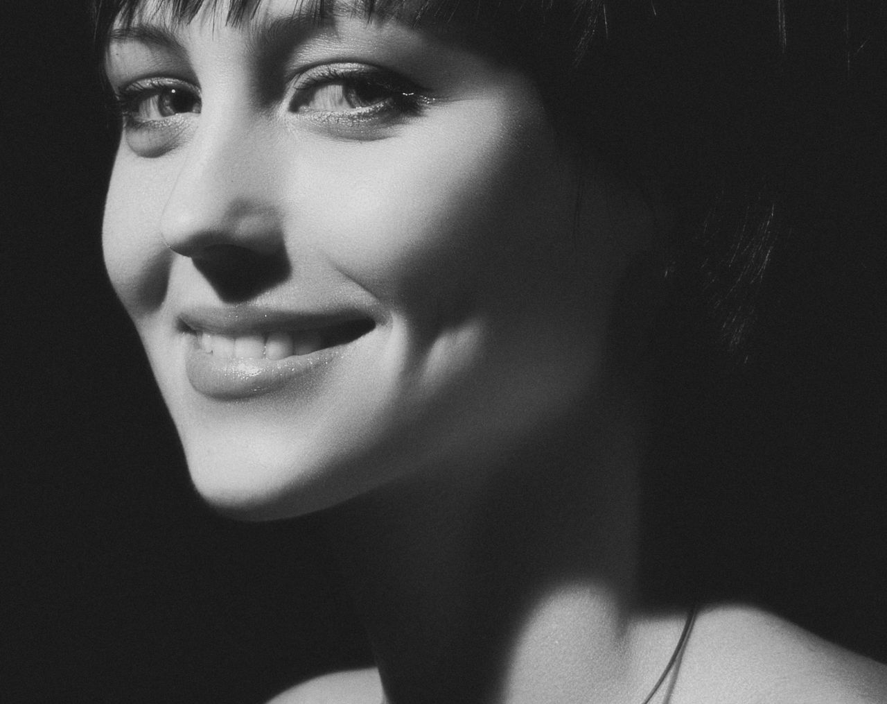 close up black and white portrait of a smiling woman with expressive e
