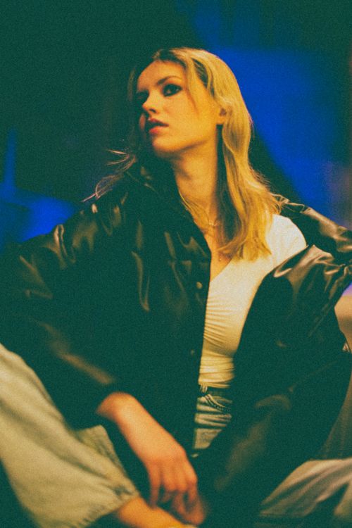 Free Moody portrait of a young blonde woman in casual wear, featuring a jacket and jeans. Stock Photo