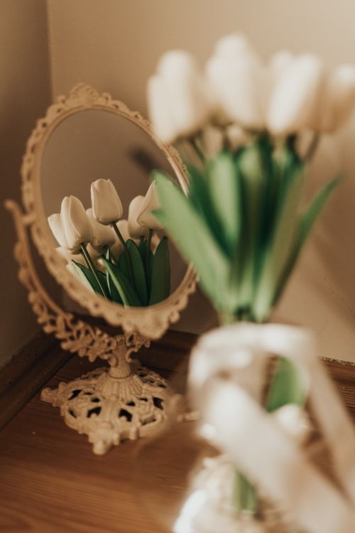 Free Charming arrangement of white tulips reflected in ornate vintage mirror, creating a soft spring ambiance. Stock Photo