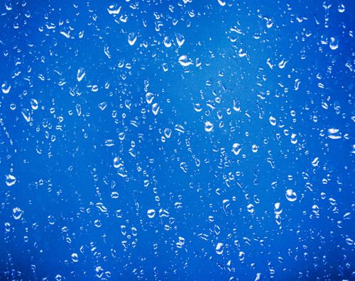 Free Artistic close-up of raindrops on a blue glass surface, creating a textured pattern. Stock Photo