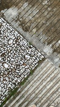 A detailed view of interlocking pebbles and wooden planks creating geometric patterns.
