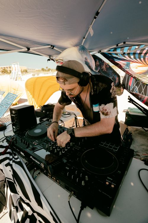 Free A DJ mixes music under a sunshade at a vibrant beach festival in St. Petersburg, FL. Stock Photo
