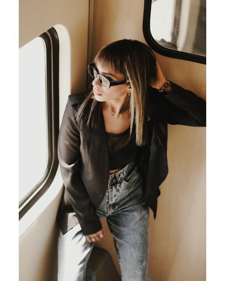 Woman In Sunglasses Posing In Train Near Window