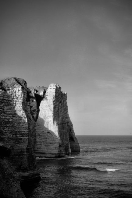Stunning black and white photo of the iconic cliffs in Étretat, Normandy, France.