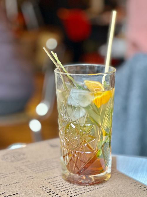 Free Chilled cocktail with ice, citrus, and straw in a decorative glass. Ideal for refreshing beverage images. Stock Photo