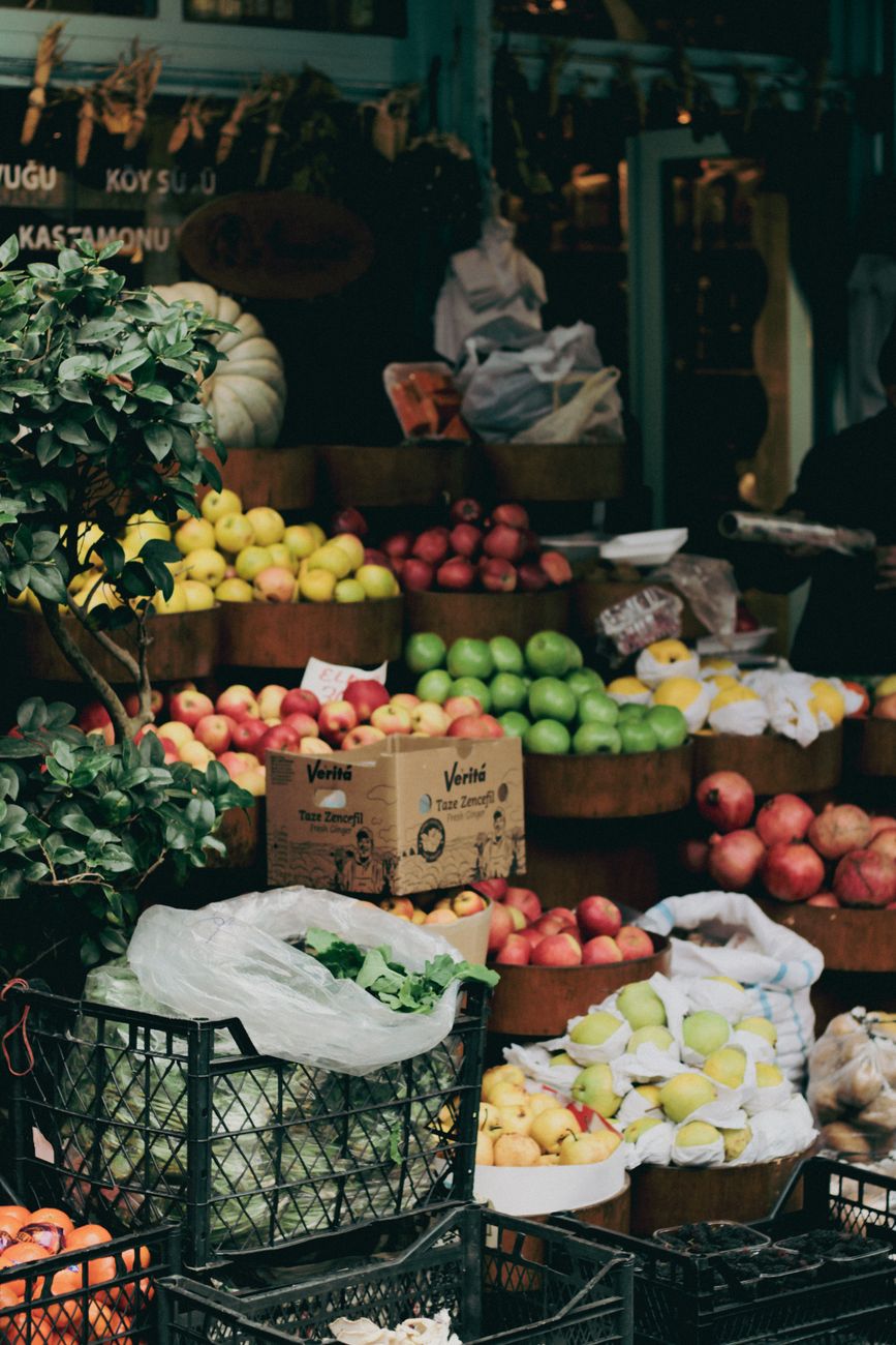 Colorful display of fresh fruits and vegetables at an outdoor market stall, showcasing apples, lemons, and greens.. pexels, c