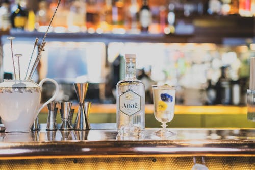 A Cocktail and a Gin Bottle Standing on the Bar Counter 
