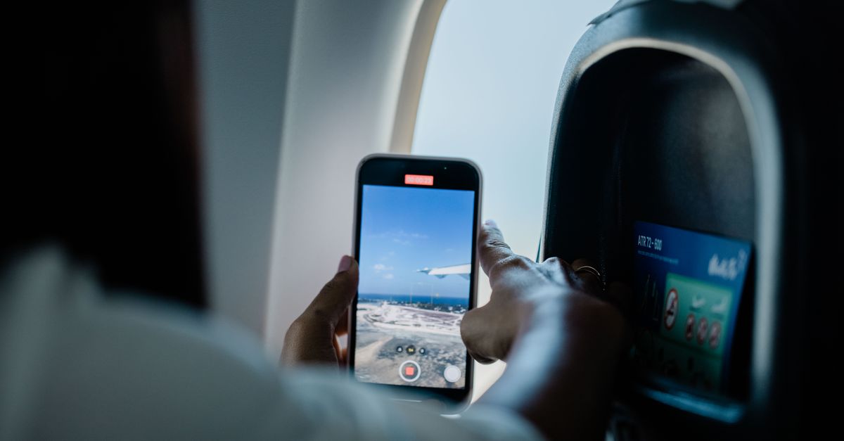 A smartphone resting on a wooden table displaying a clean text conversation managing a flight itinerary.