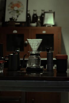 Elegant setup for brewing coffee in a cozy café, featuring glass coffee pot and kettle.