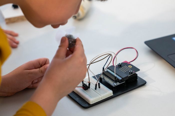 Child assembling an electronic circuit with a microcontroller