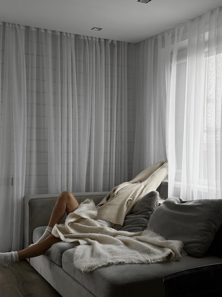 Photo Of A Person Covered With A Blanket While Resting On A Couch