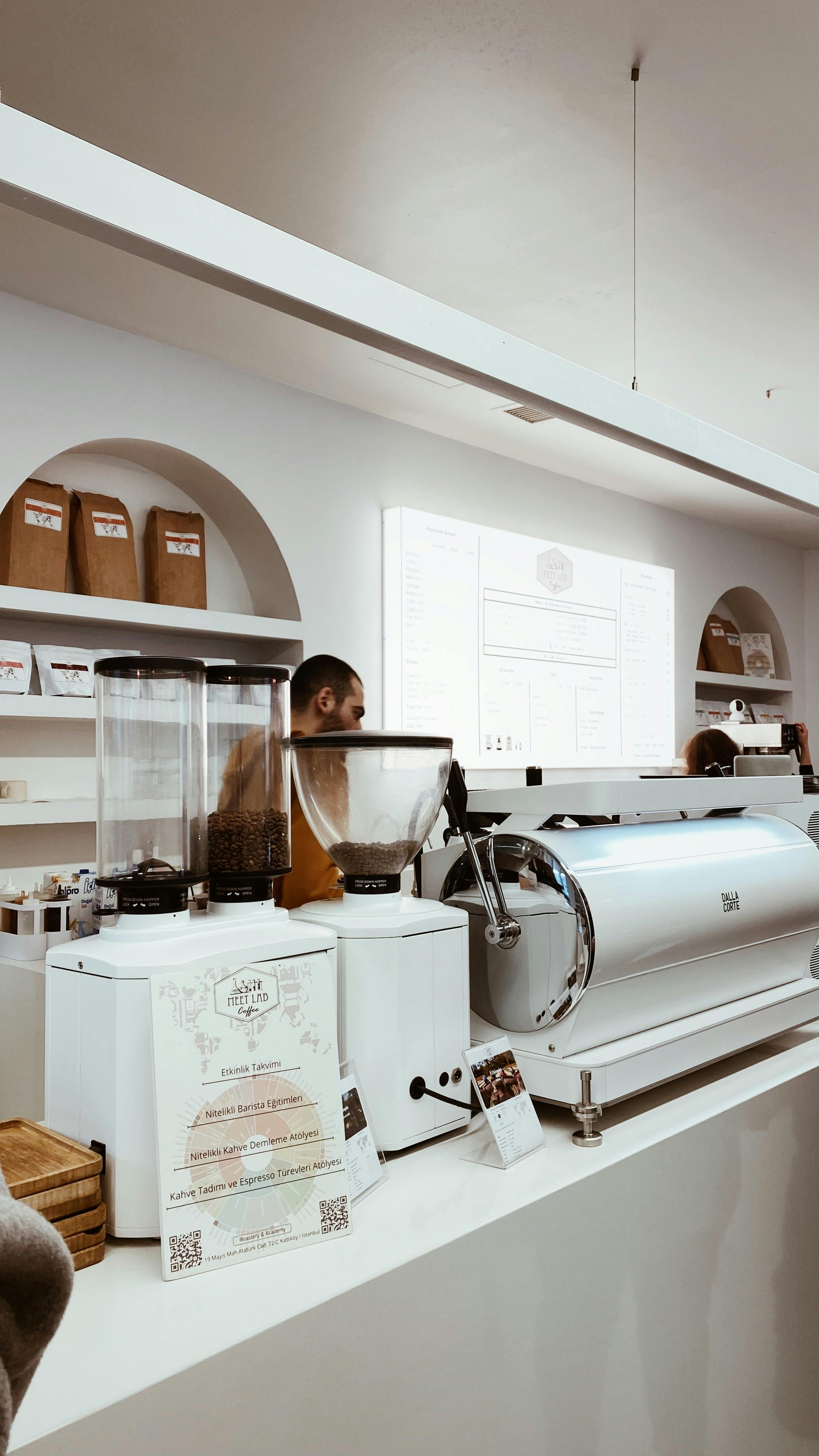 Contemporary coffee shop showing espresso machines and grinders with staff working.