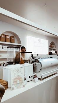 Contemporary coffee shop showing espresso machines and grinders with staff working.
