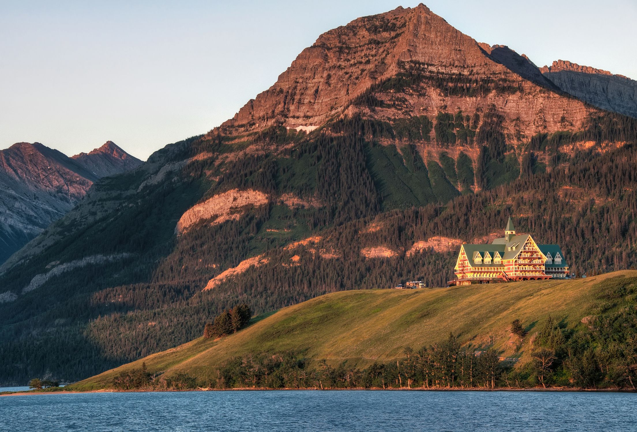 A captivating view of Prince of Wales Hotel with mountains and lake in Waterton Park, Canada.