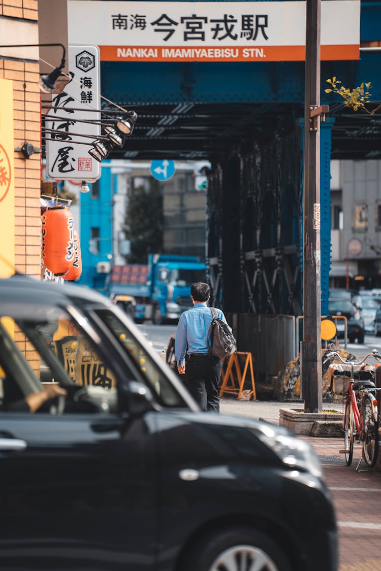 Man Walking City Street Under Bridge