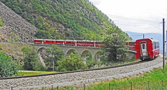 Red Train on Black Steel Train Rail during Day