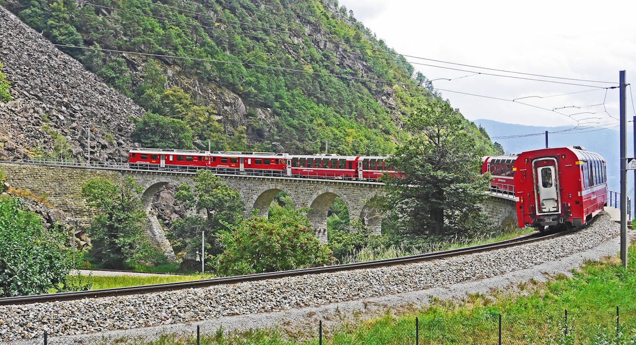 無料 日中の黒い鋼の列車のレール上の赤い列車 写真素材