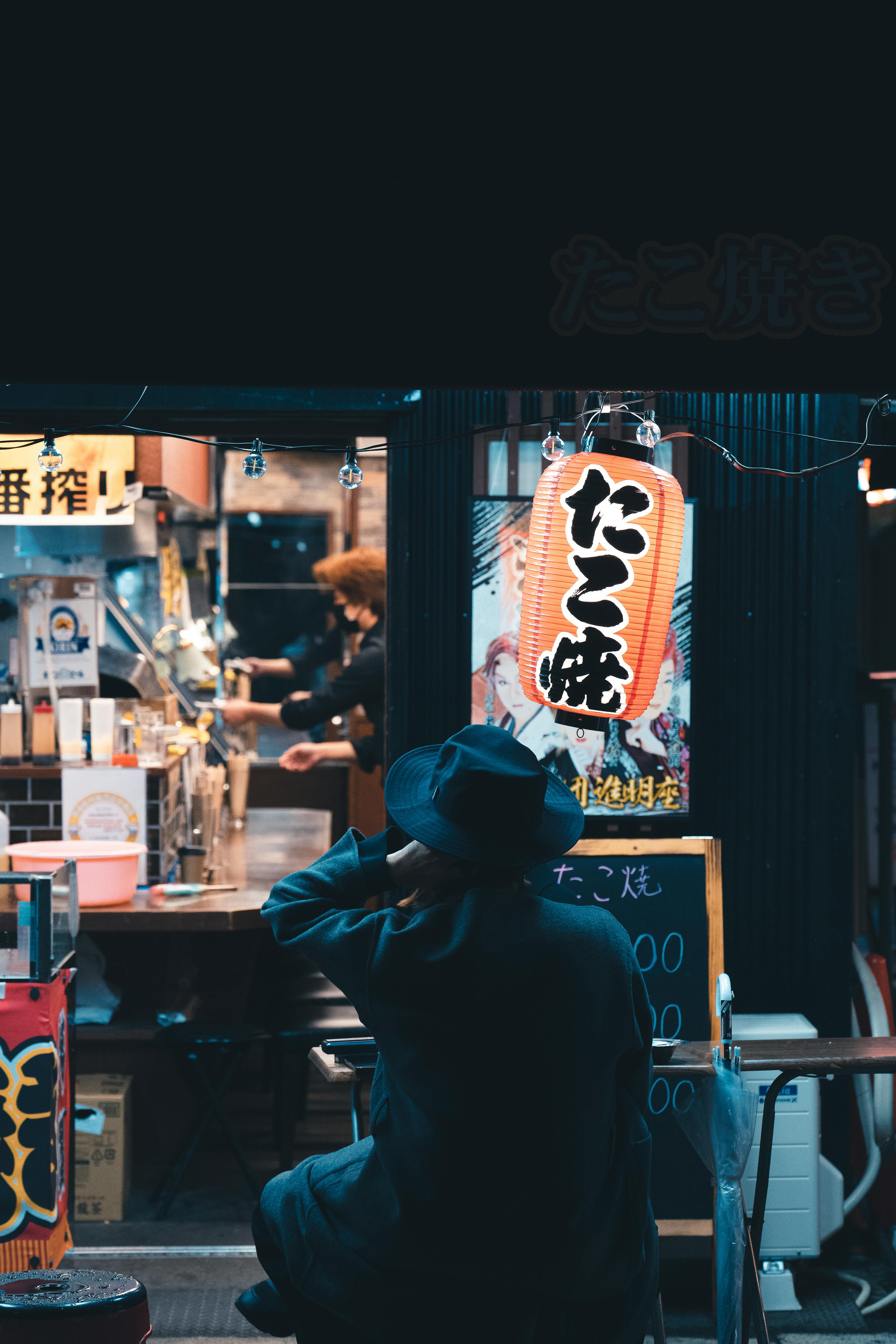 Person Sitting at a Table on a Restaurant Patio in Japan · Free Stock Photo