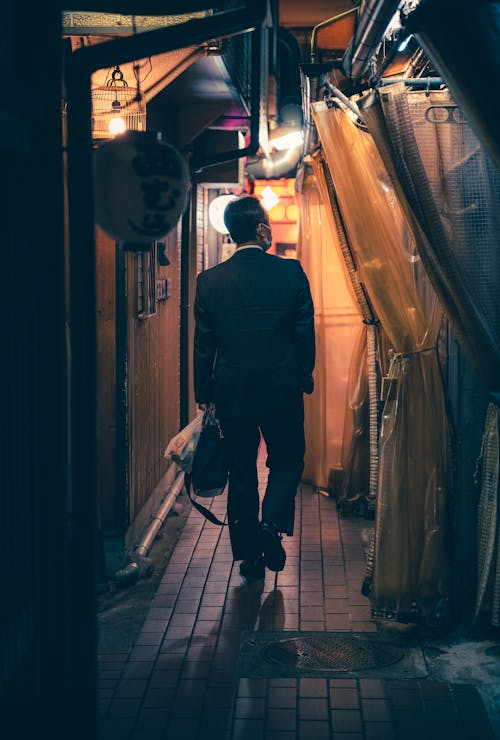 Man in a Suit Walking in a Narrow Alley 