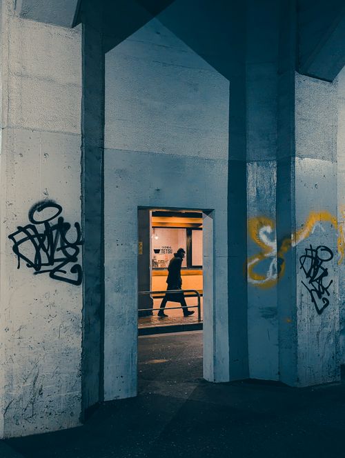 Free A person walks through a subway doorway framed by graffiti in Tokyo's Taito City. Stock Photo