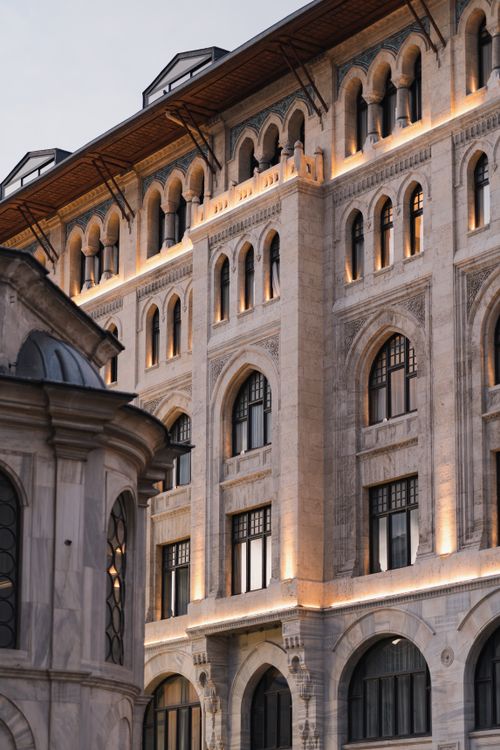 Free Elegant historic building facade with arches and detailed exterior at dusk. Stock Photo