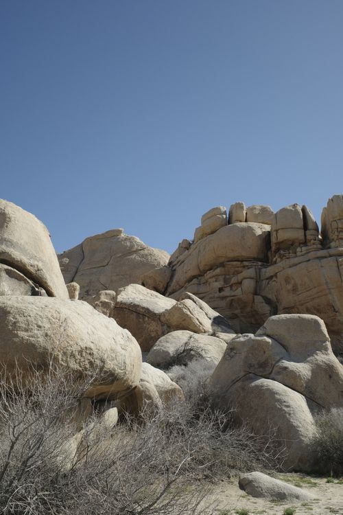 Free Explore towering rock formations in an arid desert landscape with clear blue skies. Stock Photo