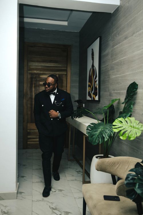 Free Stylish man in black suit with sunglasses walking in a modern interior hallway. Stock Photo