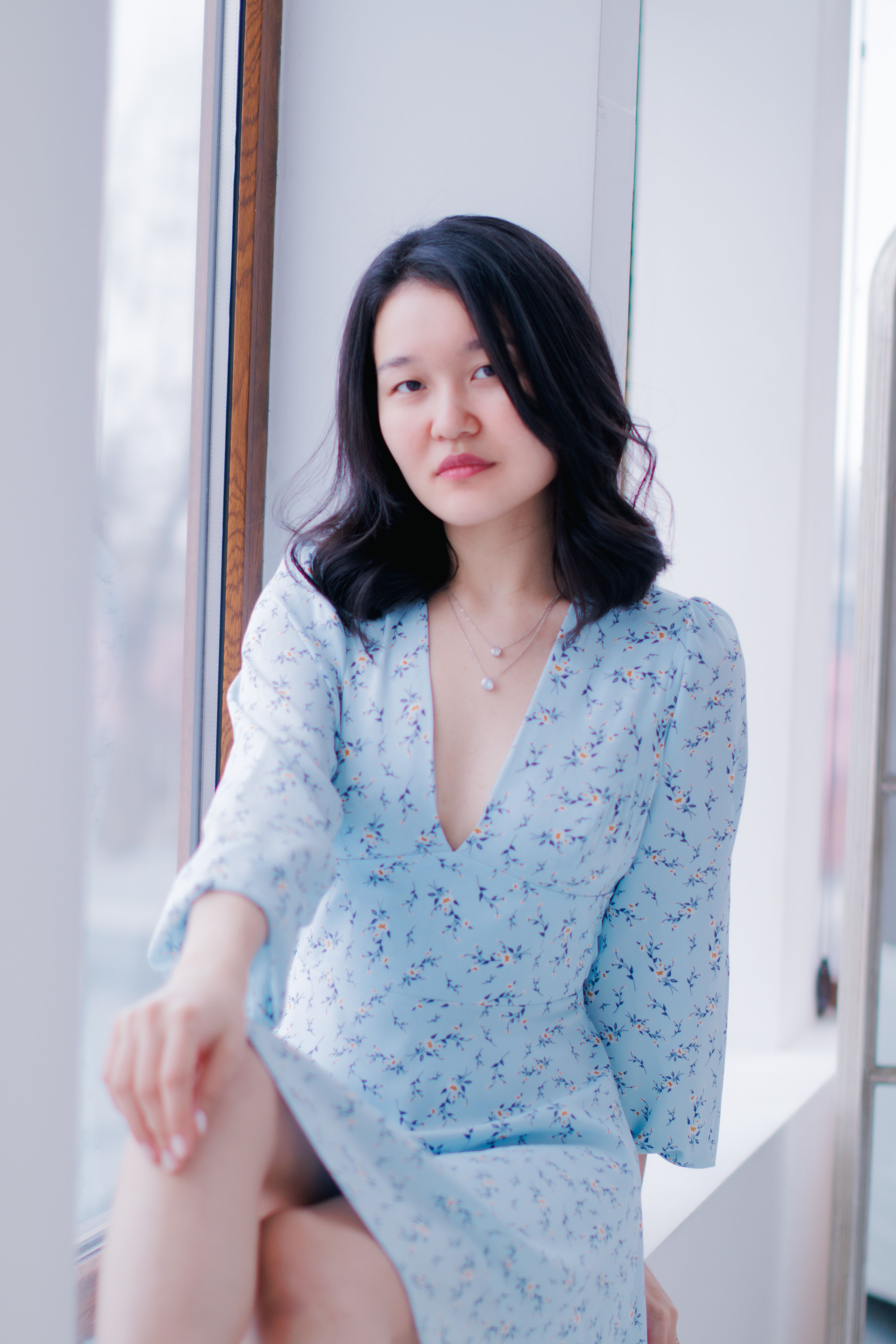 Elegant Woman in Light Blue Floral Dress by Window · Free Stock Photo