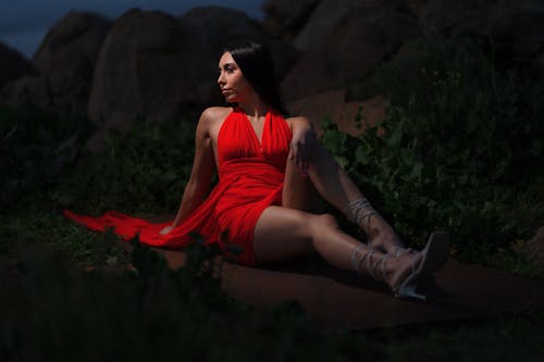 Young Woman in a Red Dress Posing Outdoors in the Dark 