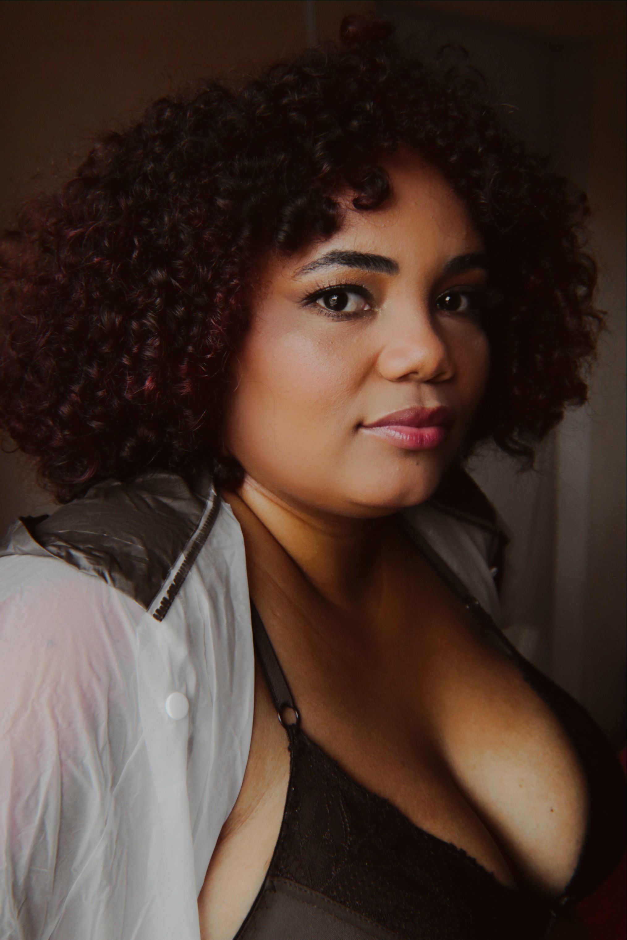 A fashionable portrait of a woman with curly hair and stylish attire, perfect for fashion photography.