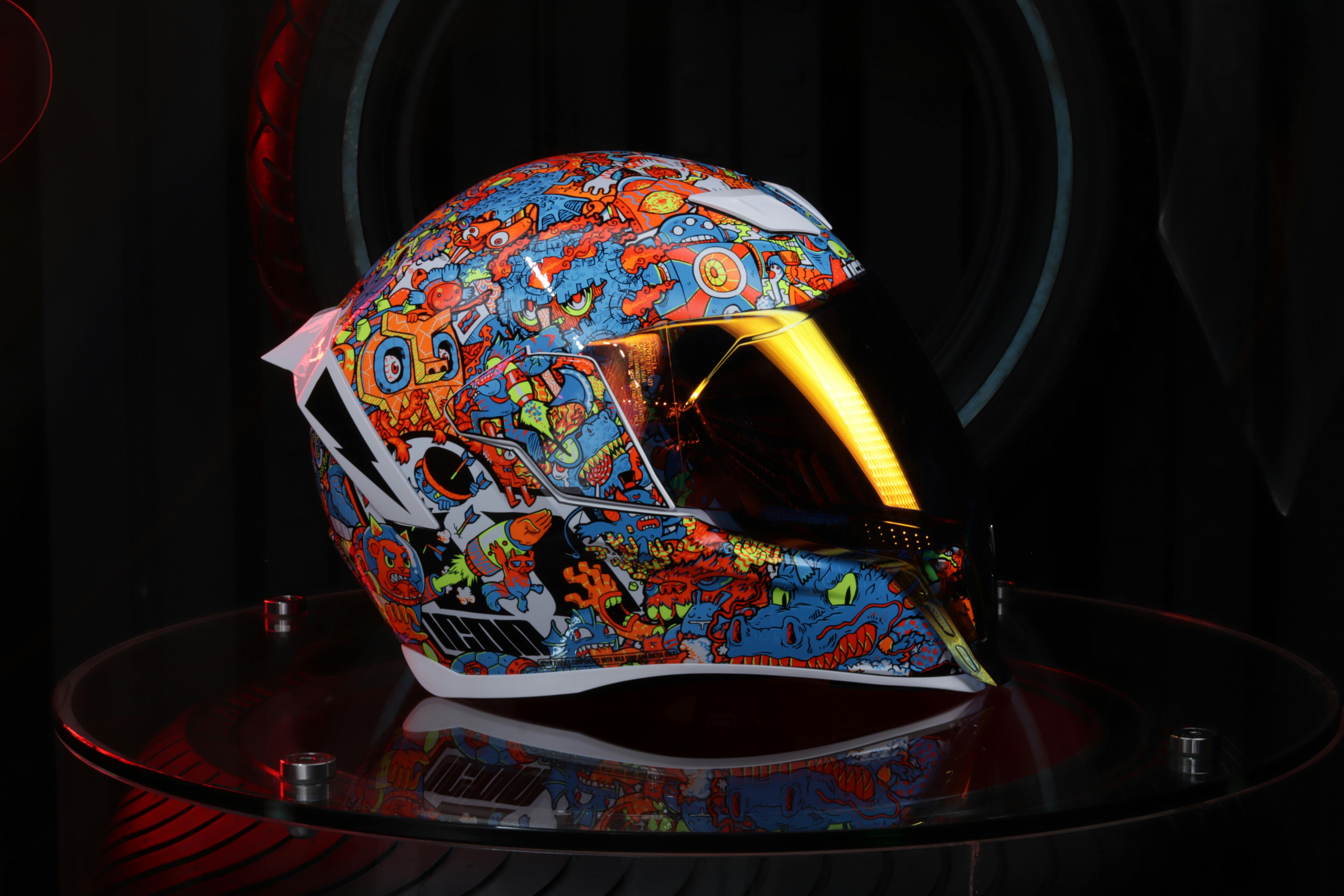 Close-up of a colorful motorcycle helmet featuring abstract patterns and designs, captured indoors.