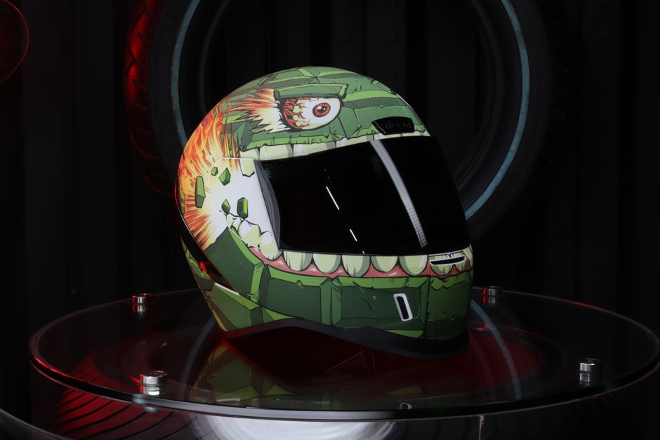 Close-up of a uniquely painted futuristic motorcycle helmet in a studio setting.