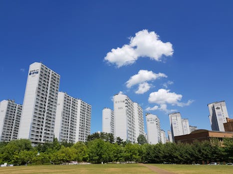 Skyline of high-rise apartments in Yongin with clear blue sky and clouds.
